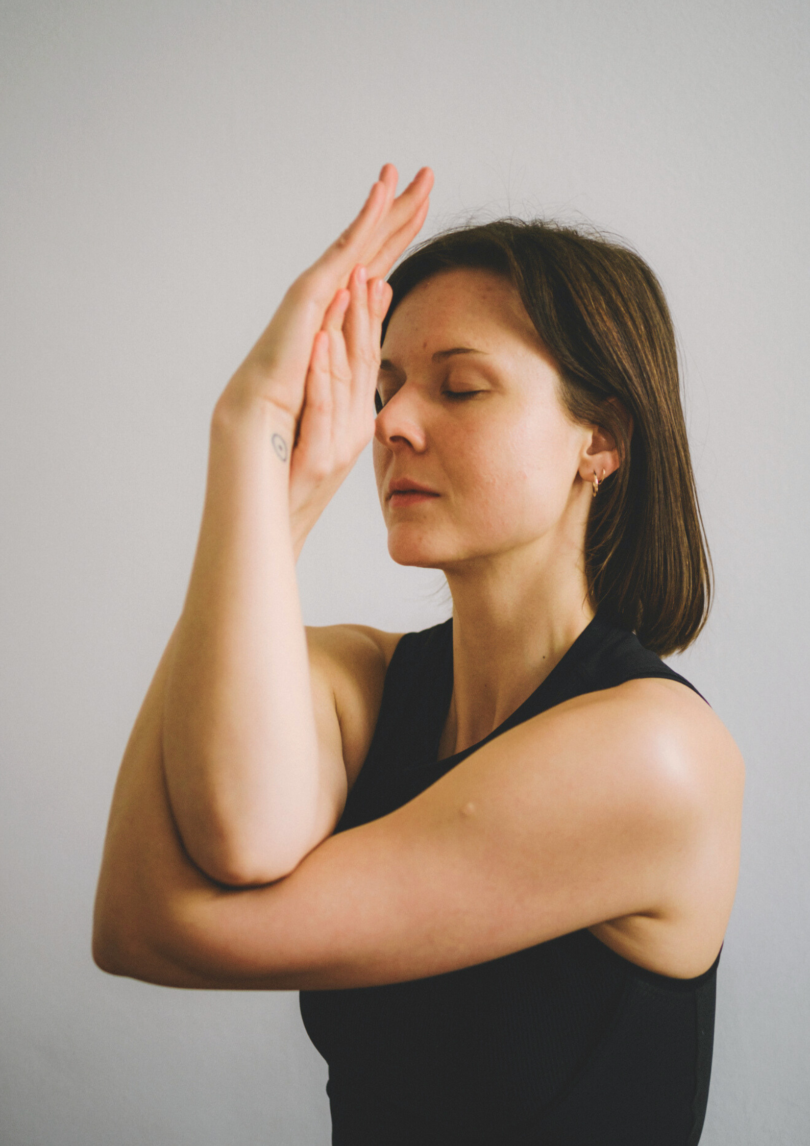 Charlotte Zehentmeier zeigt die Yogahaltung Garudasana, den Adler ,mit ihren Armen.