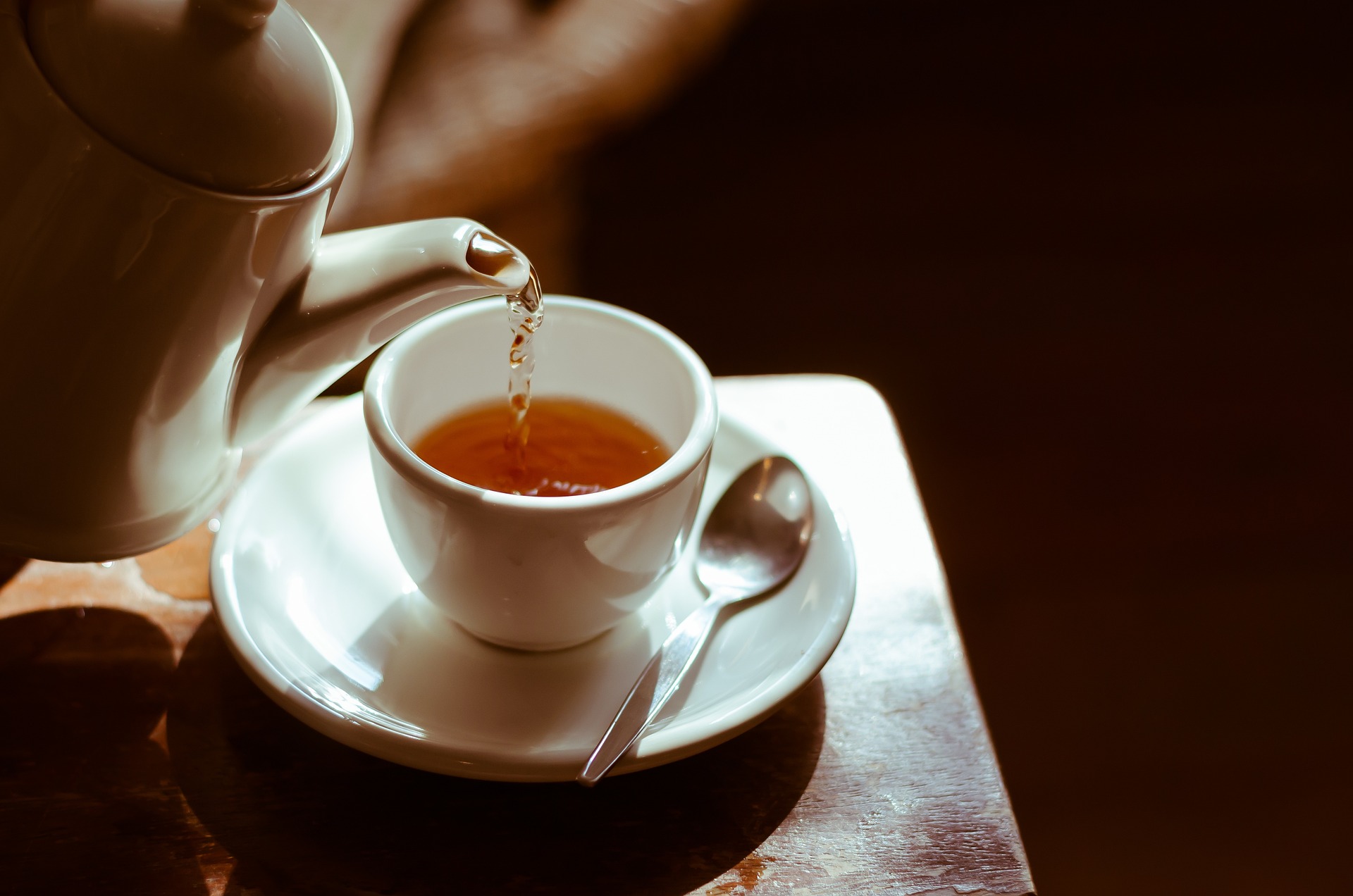 Es wird eine Teetasse mit dampfendem Tee eingegossen.